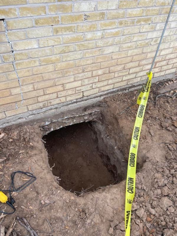 A whole dug under a house so the plumber can get to the pipes.